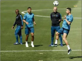  ?? FRANCISCO SECO — THE ASSOCIATED PRESS ?? Real Madrid’s Cristiano Ronaldo, right, heads the ball during a training session on the open media day at the team’s Veldebebas training ground in Madrid, Tuesday. Real Madrid will play the Champions League final match against Liverpool on Saturday 26.