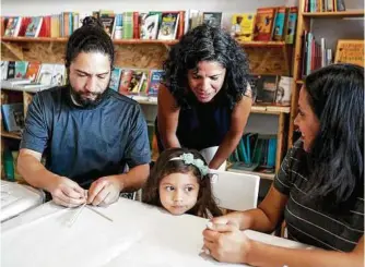  ?? Chris Carlson / Associated Press ?? Celene Navarette, second from left, helps Ella J. Varela with an art project as her father, Eric, and her mother, Enia, look on.