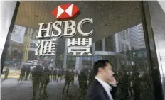  ?? — Reuters ?? Man walks past a logo of HSBC outside a branch at the financial Central district in Hong Kong.