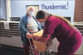  ?? Photo by Ernest A. Brown ?? Health care profession­al Carlene Watts, right, assists Susie Cassey by placing a large box of food items in the cart she uses with her cane to get around, at Thundermis­t Health Center in Woonsocket Thursday.