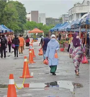  ?? PIC BY FAIZ ANUAR ?? People adhering to standard operating procedures at a farmer’s market in Shah Alam yesterday.