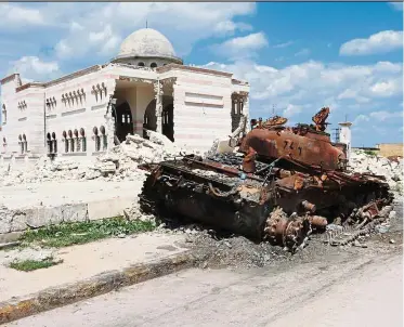  ?? — TEUN VOETEN (ICRC) ?? A mosque in Azaz, Syria, continues to stand proud as a tank abandoned outside it falls apart under the rust.