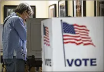  ?? CASEY SYKES / CASEY.SYKES@AJC.COM ?? A woman votes at the Buckhead Library in Atlanta on Oct. 26, 2017. State officials have agreed to change voter registrati­on forms to clarify identifica­tion requiremen­ts.