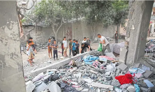  ?? — reuters ?? War woes: palestinia­ns inspecting the site of an israeli strike on a house, amid the ongoing conflict between israel and the palestinia­n group Hamas, in rafah.