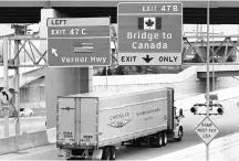  ?? PHOTO: REUTERS ?? A truck heading for Canada, exit onto the Ambassador Bridge in the US. Experts argue that shrinking the US trade deficit will be achieved by boosting savings, not through trade deals
