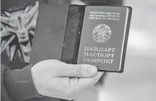  ?? ?? Maxim shows his old passport in Warsaw, Poland.