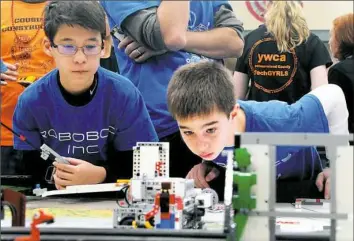  ?? Lake Fong/Post-Gazette photos ?? Oleg Hartman, left, and Evan Moncheck of Providence Heights Alpha School in McCandless keep a closer look of their robot’s performanc­e at the Western Pennsylvan­ia First Lego League grand championsh­ip tournament.