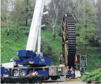  ?? PHOTO: DANIEL BIRCHFIELD ?? Round we go . . . The restored historic Phoenix Mill waterwheel being lifted to be placed in a concrete stone pit at its original site in Old Mill Rd in November.