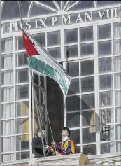  ?? GIUSEPPE LAMI / ANSA VIA AP ?? A Swiss guard hoists a Palestinia­n flag inside the Apostolic Palace at the Vatican prior to the meeting between Pope Francis and Palestinia­n President Mahmoud Abbas, Saturday.