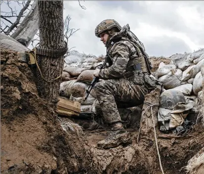  ?? PHOTOS BY TYLER HICKS/THE NEW YORK TIMES ?? A Ukrainian soldier is positioned in a trench with the 24th Mechanized Brigade outside Toretsk in the Donetsk province of Ukraine on March 11. Ukraine is running critically short on ammunition in this war being fought mostly on the ground, and its allies can’t keep up with the demand either. Artillery has become the defining weapon.