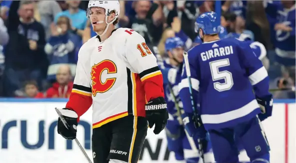  ?? MIKE CARLSON/THE ASSOCIATED PRESS ?? Calgary Flames winger Matthew Tkachuk can only skate away as Tampa Bay Lightning players celebrate one of their six goals Tuesday in Tampa, Fla.