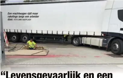 ?? FOTO DIRK ROEFFLAER ?? Een vrachtwage­n rijdt maar rakelings langs een arbeider door.