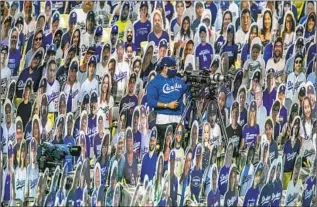  ?? Robert Gauthier Los Angeles Times ?? A CAMERA operator works amid a sea of cardboard fans on July 23 as the Dodgers and San Francisco Giants play the opener of a shortened 2020 season at Dodger Stadium.