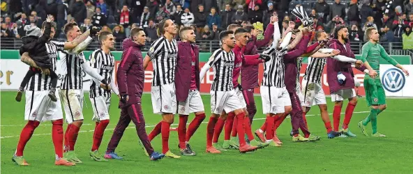  ?? FOTO: IMAGO ?? Rückkehrer Marco Russ (links, mit seiner Tochter auf dem Arm) und seine Frankfurte­r Teamkolleg­en feiern mit den Fans den Einzug ins Pokal-Halbfinale.