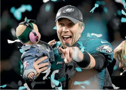  ?? GETTY IMAGES ?? Nick Foles of the Philadelph­ia Eagles celebrates with his daughter Lily after his team’s 41-33 victory over the New England Patriots in Super Bowl LII.