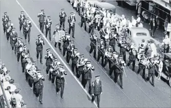  ??  ?? The Kitchener Musical Society Band marches along King Street as part of the Labour Day parade in Kitchener in the 1950s.