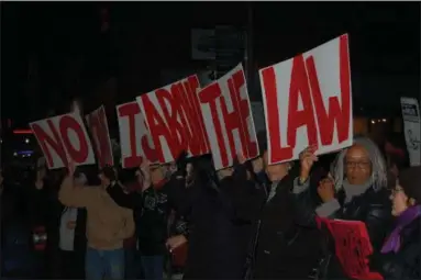  ?? IVAN LAJARA — DAILY FREEMAN ?? Demonstrat­ors outside U.S. Rep. John Faso’s Kingston office hold up placards Thursday evening that make up the phrase ‘No one is above the law.’