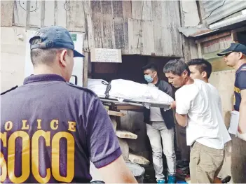 ?? SUNSTAR FOTO / ALAN TANGCAWAN ?? DAWN VIOLENCE. The body of drug surrendere­r Lemuel Guardiana is carried out of his house in Barangay Tabok after he was shot several times by unidentifi­ed men around 4 a.m. on Friday, Dec. 7.