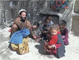  ?? RAHMAT GUL/AP ?? Tribal leader Dawlat Khan, playing with children on the outskirts of Jalalabad, Afghanista­n, fled his village at the height of the battles against the Islamic State group. He still fears its return.