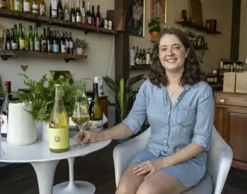  ?? Benjamin B. Braun/Post-Gazette ?? Maddie Burton, store manager of Cuvee Bottle Shop, with a bottle of German hard cider, Wein Goutte Apfel Cidre.