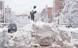  ?? DAVID ZALUBOWSKI/AP ?? A pile of snow sits beneath a sculpture as a motorist passes by on Thursday after a late winter storm dropped up to a foot of snow in Golden, Colo.