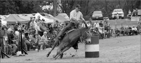  ?? Photograph courtesy of Russ Wilson ?? Colleen leans into the turn as John Higgins Jr. skillfully guided her through the barrels course to take first place in the adult division with 17.219 seconds. Higgins, of Greentop, Mo., has been competing in the Pea Ridge Mule Jump since he was a...