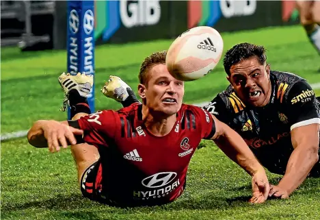  ?? PHOTOSPORT ?? George Bridge knocks the ball dead under pressure from Anton Lienert-Brown in last night’s Super Rugby Aotearoa final in Christchur­ch.