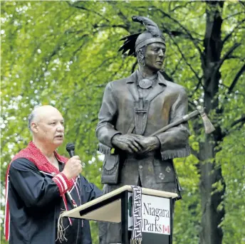  ?? HARLEY DAVIDSON/POSTMEDIA NEWS ?? Standing beside his creation, Raymond Skye, the indigenous artist responsibl­e for the Landscape of Nations memorial at Queenston Heights Park, talks a bit about his art and heritage on Saturday.