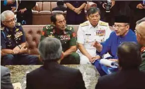  ??  ?? Defence Minister Datuk Seri Hishammudd­in Hussein (right) in discussion with security chiefs after the tabling of the 2018 Budget at the Parliament lobby in Kuala Lumpur yesterday.