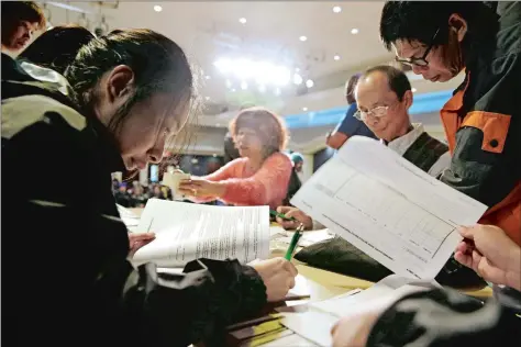  ?? ERIC RISBERG/AP FILE ?? Christina Hung, left, 23, of Oakland, Calif., fills out an applicatio­n form in March of last year during a health care enrollment event at the Oakland Asian Cultural Center. State-run health insurance markets that offer taxpayer-subsidized coverage...