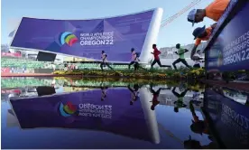  ?? Field. Photograph: Charlie Riedel/AP ?? Athletes train on the running track while workers add signage to a water jump at Hayward