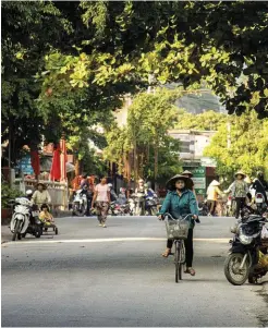 ??  ?? A Vietnamese woman cycles along Tam Coc’s main road.