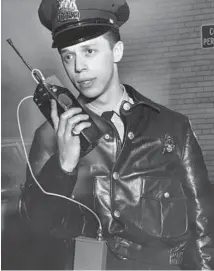  ?? VAL MAZZENGA/CHICAGO TRIBUNE ?? Police officer Michael Capesius holds a new portable two-way radio being field-tested for Motorola at East Chicago police station on March 21, 1967.