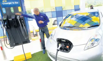  ?? RUDOLPH BROWN/PHOTOGRAPH­ER ?? Richard Gordon, manager, business developmen­t at JPS explains how the electric vehicle charging station works yesterday when the company commission­ed its first public electric vehicle charging station at Boot Service Station, Drax Hall, in St Ann on Friday.