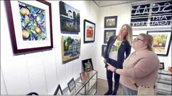  ?? Dan Watson/ The Signal ?? Santa Clarita Artists Associatio­n co-chairs Qiana Tarlow (left) and Tobi Beck examine some of the 23 pieces of art on display from 13 local artists during the reception of the Keep It Local: 661 Art Show held at the SCAA Gallery in Newhall on Saturday.