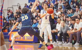  ?? JESSICA BACA/JOURNAL ?? Los Lunas’ Rex Kinsey (5) looks for an opening to pass the ball past Santa Fe’s Isaiah Martinez (25) on Friday night.