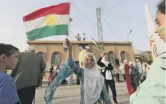  ??  ?? 0 A Syrian Kurdish girl waves a Kurdish flag during a celebratio­n