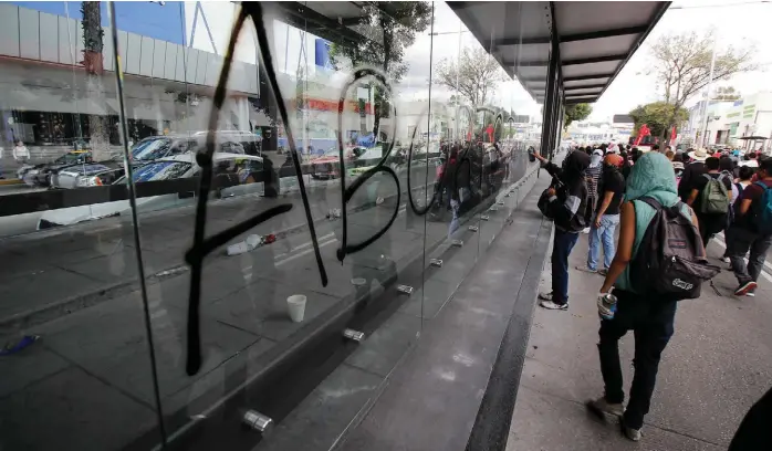  ??  ?? Jóvenes con rostros tapados realizaron pintas en una de las paradas de la Línea 3.