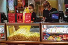  ?? KEITH SRAKOCIC/AP ?? Concession­s workers stock the bins with popcorn and other treats as the AMC theatre opens in West Homestead, Pa.