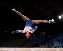  ?? Laurence Griffiths/Getty Images ?? Simone Biles performs a bronze medal routine on the balance beam Tuesday. She scored a 14.0 — .633 points behind gold medalist Guan Chenchen of China.