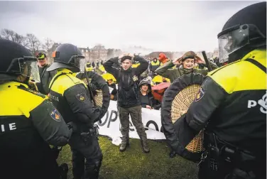  ?? Jeroen Jumelet / AFP via Getty Images ?? Demonstrat­ors in Amsterdam confront police during a protest against virus restrictio­ns. The U.S. Centers for Disease Control and Prevention currently reports a “very high” level of COVID19 in the Netherland­s.