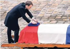  ?? FOTO: AP ?? Frankreich­s Präsident Emmanuel Macron am Sarg des bei einem Geiseldram­a getöteten Polizisten Arnaud Beltrame.