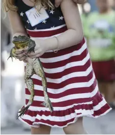  ??  ?? Photograph­er Notes: (ABOVE) An eager contestant gets her amphibious friend ready for the frog jumping competitio­n held at the annual Tom Sawyer Days Festival in Hannibal, Missouri.