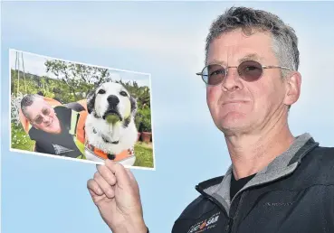  ?? PHOTO: GREGOR RICHARDSON ?? Memories . . . LandSAR volunteer Dermot Mayock holds a picture taken of him and his dog, Fin, when Fin retired in October 2017.
