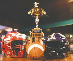  ?? BEA AHBECK/NEWS-SENTINEL ?? Above: Helmets and the Grape Bowl champions trophy during a football luncheon with Lodi and Tokay High players in Lodi on Wednesday. Below: Lodi coach George Duenas and Tokay coach Mike Holst speak during Wednesday’s luncheon at Tony’s Pizzeria.