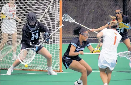  ?? FERRON/BALTIMORE SUN KARL MERTON ?? Maryland attacker Brindi Griffin (1) shoots around Johns Hopkins midfielder Madison McPherson to score on goalkeeper Kathleen Garvey (24) during the first half Wednesday.