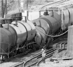  ?? Dave Moll/ Postmedia News ?? Workers move petroleum fluids from tankers sagging on the partially collapsed Bonnybrook Canadian Pacific bridge Thursday.