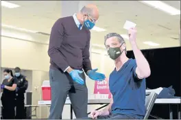  ?? BRITTANY MURRAY — PRESS-TELEGRAM ?? Gov. Gavin Newsom displays his vaccinatio­n card in Baldwin Hills on April 1 after receiving a Johnson & Johnson dose from Dr. Mark Ghaly, the state health secretary.