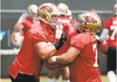  ?? Tony Avelar / Associated Press ?? Tackle Mike McGlinchey (left), the first-round pick, and center Coleman Shelton mix it up in organized team activities in May in Santa Clara.