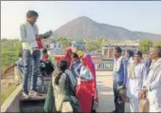  ?? HT PHOTO ?? Villagers in Karauli on the roof of a building searching for network to make the PoS machine work.